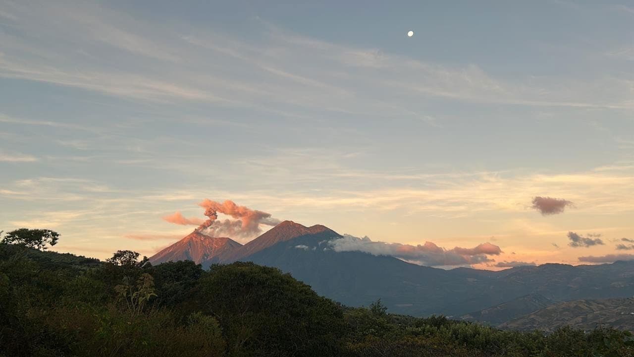 Volcán de Fuego at dusk seen from Camino 5, with the moon rising over the valley